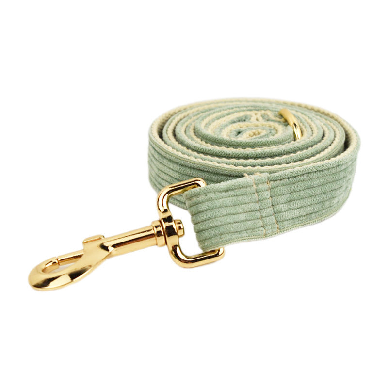 A set of dog pet accessories including a collar, leash, bow, flower decoration, and a vest, all in green with a gold leaf pattern.
