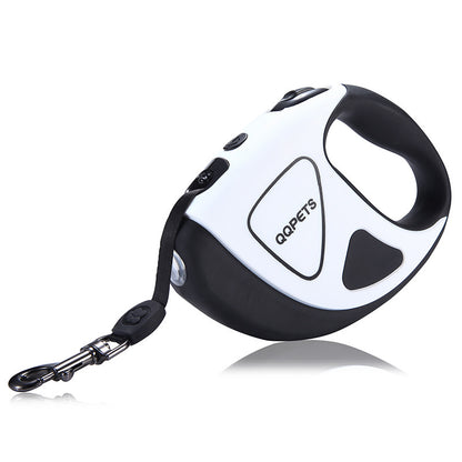 A hand holding a retractable dog leash with an LED shining button, predominantly black and white in color.