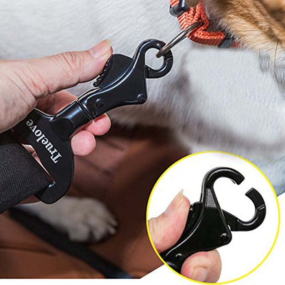 A black dog seat belt made of aluminum, being fastened onto a dog's collar by a person.